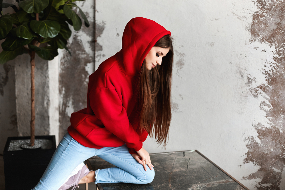 Girl wearing a dark hoodie and light jeans
